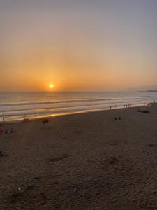 a group of people on the beach at sunset at Résidence Borj-Dlalate City center Agadir in Agadir
