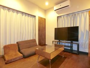 a living room with a couch and a flat screen tv at futaba heights - Vacation STAY 15533 in Tokyo