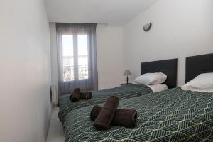 a bedroom with two beds with towels on them at "Évasion"-Meublé de Tourisme 3 étoiles -Résidence "Les Logis de Béziers"-Garage optionnel-Cœur de ville-Plages à 16km ! in Béziers