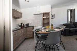 a kitchen and dining room with a table and chairs at "Évasion"-Meublé de Tourisme 3 étoiles -Résidence "Les Logis de Béziers"-Garage optionnel-Cœur de ville-Plages à 16km ! in Béziers
