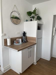 a kitchen with white cabinets and a white refrigerator at Au repos de la Croix Rouge - Studios et Apt tout équipés - proche gare in Châtellerault