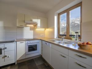 a kitchen with white cabinets and a sink and a window at Ferienhaus Hansl in Prama