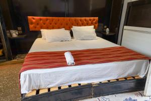 アズルーにあるMaison Duffalの大型ベッド(オレンジ色のヘッドボード、白い枕付)