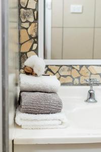 uma pilha de toalhas sentadas num lavatório na casa de banho em Toowoomba Hospital Apartments em Rockville