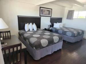 a hotel room with two beds and a desk at The View Motel in Cottonwood