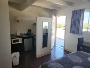 a bedroom with a bed and a kitchen with a door at The View Motel in Cottonwood