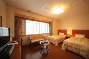 a hotel room with two beds and a television at Hotel Tappi in Satogahama +32 photos