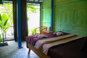 1 dormitorio con 1 cama con toallas en Villa Kamar Tamu Selomartani 2, en Sleman