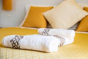 a stack of towels sitting on a bed at Blu Mare Lampedusa Bed And Breakfast in Lampedusa