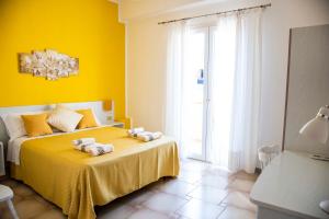a yellow bedroom with a bed with towels on it at Blu Mare Lampedusa Bed And Breakfast in Lampedusa