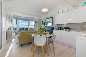 a kitchen and living room with a table and a couch at Sea Salt sea views parking in St Ives