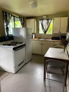 een keuken met een fornuis, een koelkast en een tafel bij Hana Maui Vacation Rentals "HOME" Hana Hale in Hana