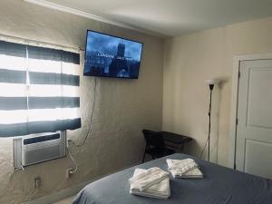 a bedroom with a bed with a tv on the wall at Private Rooms close to Miami Airport - Free parking - 02 in Miami