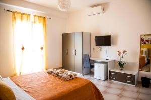 a bedroom with a bed with a desk and a cabinet at Blu Mare Lampedusa Bed And Breakfast in Lampedusa
