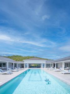 una imagen de una piscina en un edificio en 5 BR Luxurious Beachfront Villa with utmost privacy, en Les Terres Basses