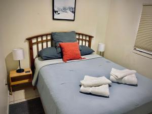 a bed with two pillows and towels on it at Cozy rooms in cute house, close to Miami airport - Free parking in Miami
