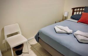 1 dormitorio con 1 cama azul y 1 silla blanca en Cozy rooms in cute house, close to Miami airport - Free parking, en Miami