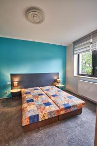 1 dormitorio con 1 cama grande y pared azul en Apartmán u Martina, en Jablonec nad Nisou