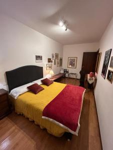 ein Schlafzimmer mit einem großen Bett mit einer roten und gelben Decke in der Unterkunft ART ROOM in Verona
