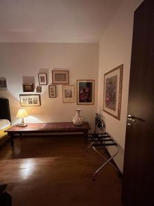 Zimmer mit einem Tisch mit einer Lampe und Bildern an der Wand in der Unterkunft ART ROOM in Verona