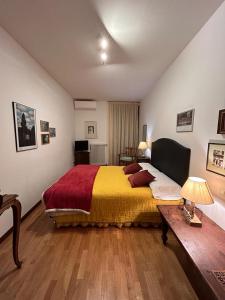 ein Schlafzimmer mit einem großen Bett mit einer gelben und roten Decke in der Unterkunft ART ROOM in Verona