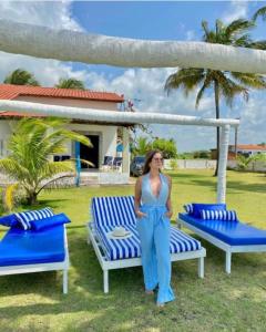 a woman standing next to two blue and white chairs at A 2 passos do paraíso in Rio Tinto