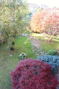 a garden with colorful flowers and trees in a yard at B&R Apartment in Caselle Torinese
