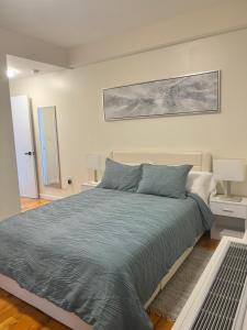 een slaapkamer met een bed met een grijze sprei bij Lore&ken shared apartment in Long Island City