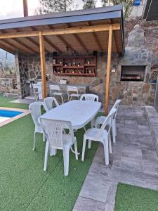 Marianna's House في Galata: طاولة بيضاء وكراسي على فناء مع موقد