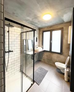 a bathroom with a glass shower and a toilet at GiGi Home's in Antwerp