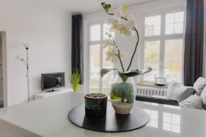 un jarrón con flores sobre una mesa en la sala de estar en Fewo Jule, en Sondershausen