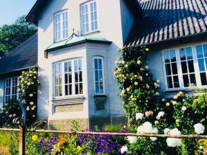 a blue and white house with flowers in front of it at NordsoeHousing-Rørby in Kalundborg