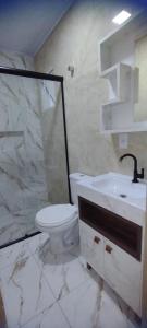 W łazience znajduje się toaleta, umywalka i prysznic. w obiekcie Morada do bosque w mieście Capão da Canoa
