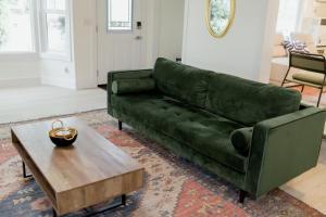 a green couch in a living room with a coffee table at Charming Kelowna Haven with Hot Tub, Parking, Pet-Friendly Bliss in Kelowna