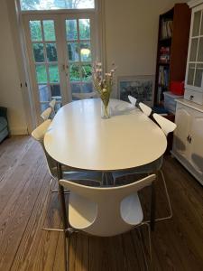 a dining room table with chairs and a vase with flowers at NordsoeHousing-Rørby in Kalundborg