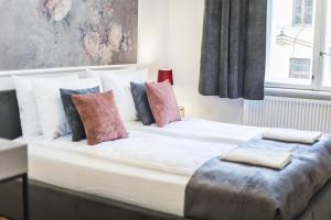 een groot wit bed met kussens erop bij CracWoW K8 No.9 Apartment in Krakau