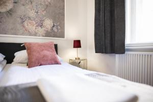 een slaapkamer met een bed met een rood kussen en een raam bij CracWoW K8 No.9 Apartment in Krakau