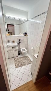 a white bathroom with a toilet and a sink at Schöne Wohnung 5 Minuten von München Messe. in Munich