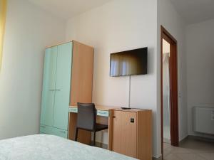 Hotel Ariston Imperial في بورتو غاريبالدي: غرفة نوم مع مكتب مع كرسي وخزانة