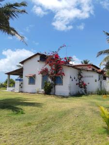a white house with red flowers on it at A 2 passos do paraíso in Rio Tinto