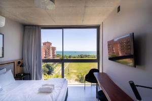 Un dormitorio con un gran ventanal con vista al mar. en Spot Jurere sofisticación junto al mar - SPJ's, en Florianópolis