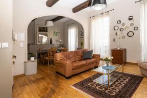 a living room with a leather couch and a table at "Air d'Antan"-Meublé de Tourisme 3 étoiles -Résidence "Les Logis de Béziers"-Garage optionnel-Cœur de ville-Plages à 16km ! in Béziers