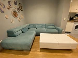 a living room with a blue couch and a white coffee table at Schöne Wohnung 5 Minuten von München Messe. in Munich