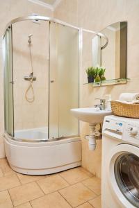 a bathroom with a shower and a sink and a washing machine at Amazing View Lux with balcony in Mukacheve