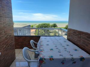 a balcony with a table and chairs and the beach at Jacaraipe, Serra ES in Serra