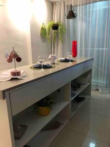 a counter with plates and wine glasses on it at AP Df Plaza varandão in Brasilia