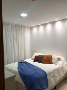 a bed in a room with a white wall at AP Df Plaza varandão in Brasilia