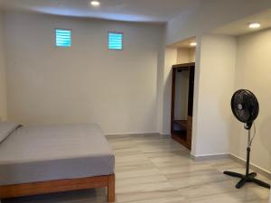 a room with a bed and a fan in it at Apartamentos mondala in Brisas de Zicatela