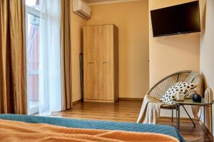 een slaapkamer met een bed, een tv en een stoel bij Amazing View Lux with balcony in Mukacheve
