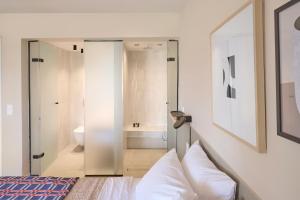 a bedroom with a bed and a bathroom with a tub at Skiathos Icon- Apartment 3 by Mojo Stays in Skiathos